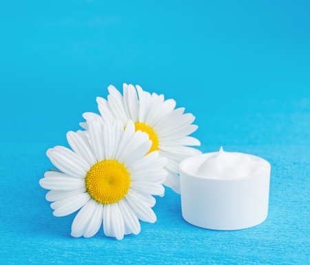 Daisy moisturizer on blue background.の写真素材