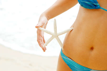 Woman with starfish on the beach の写真素材
