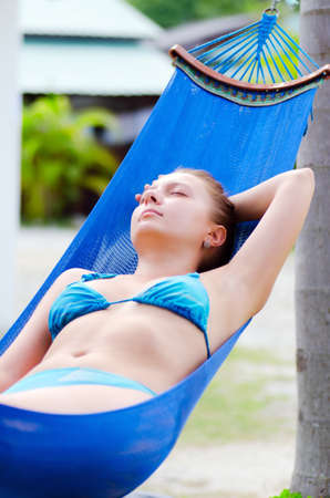 Young woman relaxing in a hammock の写真素材