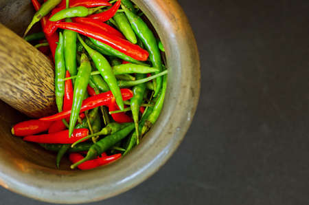 Red and green pepper in mortar.の写真素材