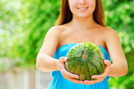 Young woman with watermelon in hands.の写真素材