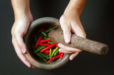 Red and green pepper in mortar.の写真素材