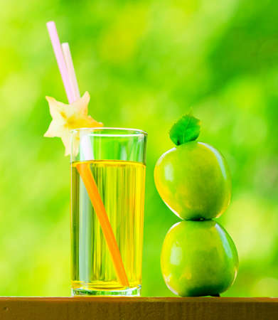 Glass of apple juice in a garden.の写真素材