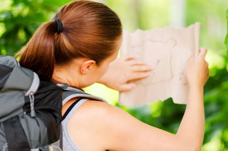 Young woman with backpack in a woods  Hiking at summertime 