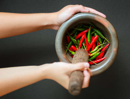 Red and green pepper in mortar.の写真素材