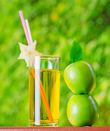 Glass of apple juice in a garden.の写真素材