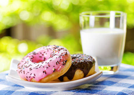 Fresh donuts and glass of milk on nature background.の写真素材