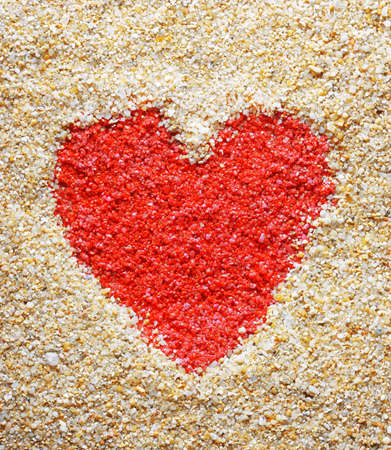 Red heart sign in yellow sand の写真素材