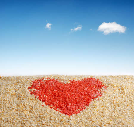 Red heart sign in yellow sand の写真素材