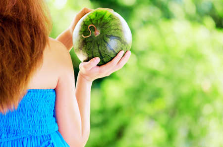 Young woman with watermelon in hands.の写真素材