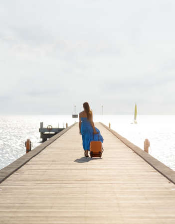 Young woman walking on wooden pier  の写真素材