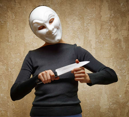 Woman in white mask holding the knife の写真素材
