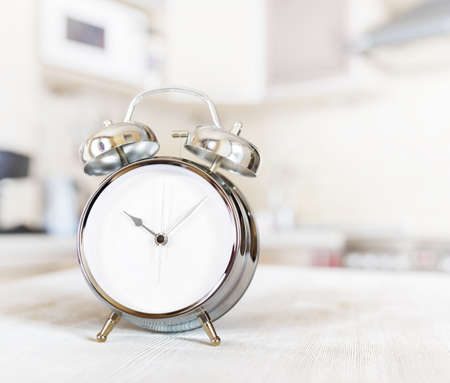 Alarm clock on a table in the kitchen.