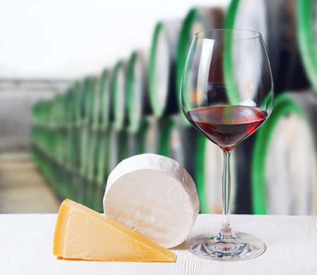 Glass of wine and cheese in winery.の写真素材