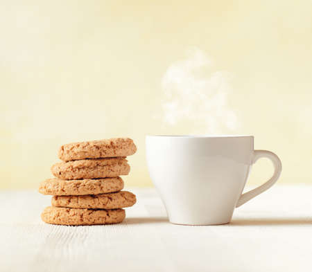 Oatmeal cookies and cup of coffee on wooden table.の写真素材