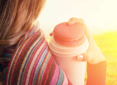 Young woman holding a tumbler of coffee  Outdoor portrait の写真素材