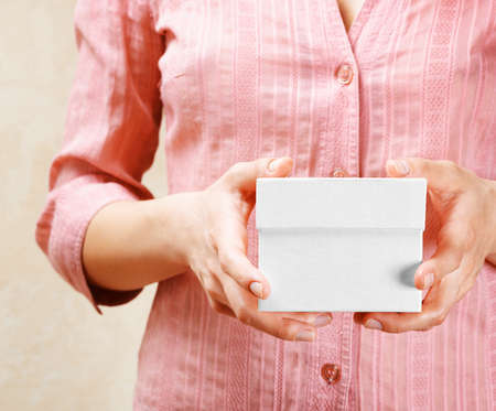 Young woman holding a white gift box の写真素材