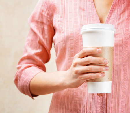 Young woman holding a tumbler of coffee の写真素材