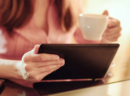 Young woman using tablet computer in cafe の写真素材