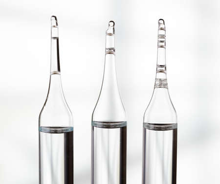 Three ampoules on light background.の写真素材