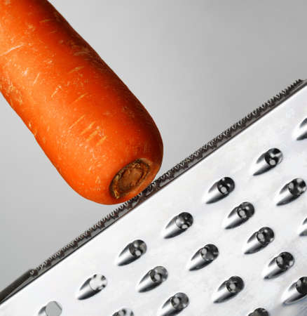 Ripe carrot rubbing on a grater.の写真素材