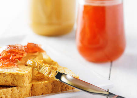 Toasts with peanut butter and strawberry jam on white table. American breakfast.の写真素材