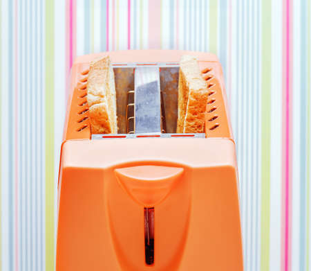 Orange toaster with two slices of bread.の写真素材