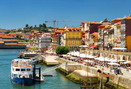 The Douro River and Colorful facades of old houses on embankment in Porto, Portugal. Porto is one of the most popular tourist destinations in Europeの写真素材