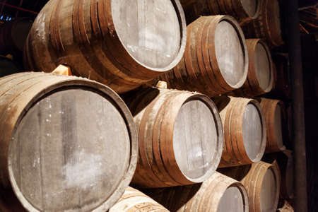 Port wine from the vineyards Douro Valley in Portugal aging in oak barrels stacked in the old cellar. Product of organic farming.の写真素材