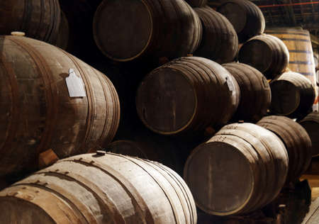 Port wine from the vineyards Douro Valley in Portugal aging in oak barrels stacked in the old...
