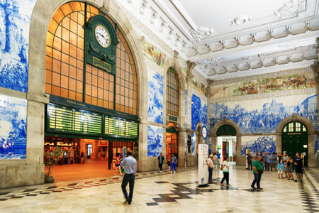 The electronic scoreboard and the old clock inside of the Sao Bento Railway Station in Porto city. The building of station is a popular tourist attraction of Europe.のeditorial素材