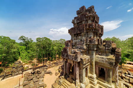 View of ancient prang from top of temple-mountain Ta Keo in amazing Angkor, Siem Reap, Cambodia. Blue sky and woods in background. Mysterious Angkor is a popular tourist attraction.の写真素材