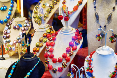 VENICE, ITALY - AUGUST 24, 2014: Colorful original jewelry from Murano Glass in shop window on the Rialto Bridge. Beautiful beads, necklaces and earrings. Venice is a popular tourist destination.のeditorial素材