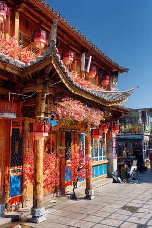 DALI, YUNNAN PROVINCE, CHINA - OCTOBER 21, 2015: Wooden facade of traditional Chinese house decorated with flowers and red lanterns in Dali Old Town. The ancient city is a popular tourist destination.のeditorial素材