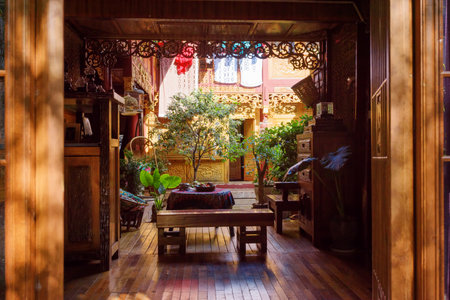 LIJIANG, YUNNAN PROVINCE, CHINA - OCTOBER 23, 2015: Amazing cozy courtyard of traditional oriental Chinese wooden house with beautiful carved walls. Courtyard decorated with potted green plants.のeditorial素材