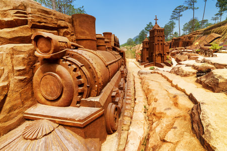 Dalat, Vietnam - March 31, 2016: Clay locomotive and church on blue sky background in amazing clay town, the Dalat Star, Da Lat. The Dalat Star is a popular tourist destination of Asia.のeditorial素材