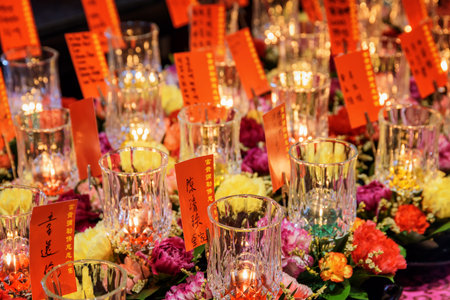 Singapore - February 17, 2017: Burning candles and ritual flowers inside the Buddha Tooth Relic Temple. The Buddha Tooth Relic Temple is a popular destination for tourists and pilgrims of Asia.のeditorial素材
