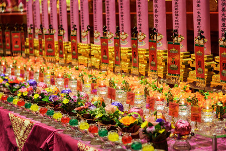 Singapore - February 17, 2017: Colorful candles and ritual flowers inside the Buddha Tooth Relic Temple in the Chinatown. The Buddha Tooth Relic Temple is a popular tourist destination of Asia.のeditorial素材