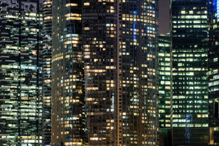 Scenic glowing windows of skyscrapers at evening. View of modern office high-rise buildings in Singapore. Amazing night cityscape.の写真素材