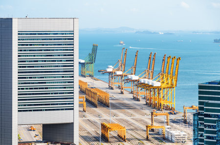 Scenic view of the Port of Singapore. Ship-to-shore (STS) gantry cranes at shipping yard on the sea background. Coastal urban industrial seascape.のeditorial素材