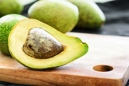 Closeup view of fresh ripe avocado on wooden cutting board. Healthy eco food. Product of organic farming.の写真素材