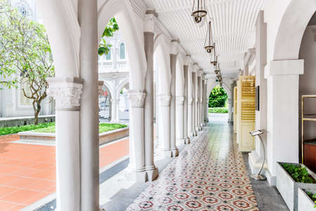 Amazing white gallery at courtyard of old colonial building at downtown of Singapore. Scenic columns and other elements of classical architecture. Singapore is a popular tourist destination of Asia.の写真素材