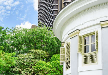 Scenic windows of old colonial building at downtown of Singapore. Wooden shutters and other elements of classical architecture. Summer cityscape. Singapore is a popular tourist destination of Asia.の写真素材