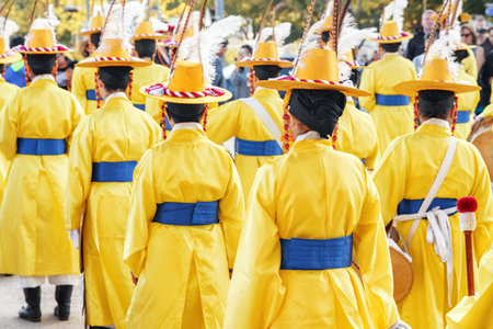 Seoul, South Korea - October 15, 2017: Performers in Korean traditional dress in front of Gwanghwamun Gate of Gyeongbokgung Palace. Women wearing yellow chonrip (hats) and po (overcoats).のeditorial素材