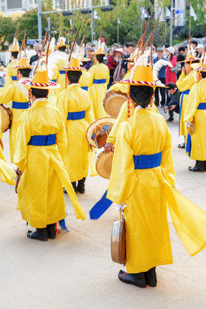 Seoul, South Korea - October 15, 2017: Performers in Korean traditional dress in front of Gwanghwamun Gate. Women wearing yellow chonrip (hats) and po (overcoats), holding drums (janggu and puk).のeditorial素材