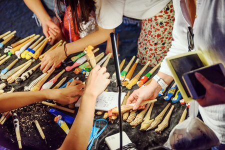 Guilin, China - September 19, 2017: Tourists choosing wooden carved colorful handmaid souvenirs at night market in Yangshuo Town. Yangshuo is a popular tourist destination of Asia.のeditorial素材