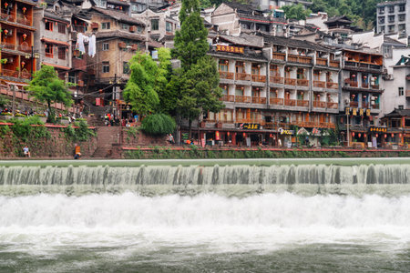 Fenghuang, China - September 22, 2017: Beautiful waterfall on the Tuojiang River (Tuo Jiang River) in Phoenix Ancient Town (Fenghuang County). Traditional Chinese riverside buildings.のeditorial素材