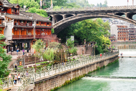 Fenghuang, China - September 22, 2017: Amazing view of Phoenix Ancient Town (Fenghuang County). Traditional Chinese wooden buildings, water wheel and bridge over the Tuojiang River (Tuo Jiang River).のeditorial素材