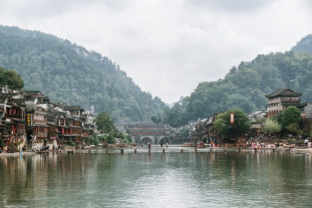 Fenghuang, China - September 22, 2017: Beautiful view of the Tuojiang River (Tuo Jiang River) and Phoenix Ancient Town (Fenghuang County). East Gate Tower of Xiangxi is visible at right side.のeditorial素材