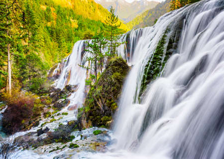 Fantastic view of the Pearl Shoals Waterfall among scenic wooded mountains and evergreen forest in...